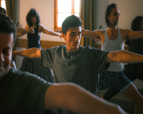 A group doing a synchronized vinyasa flow with an instructor